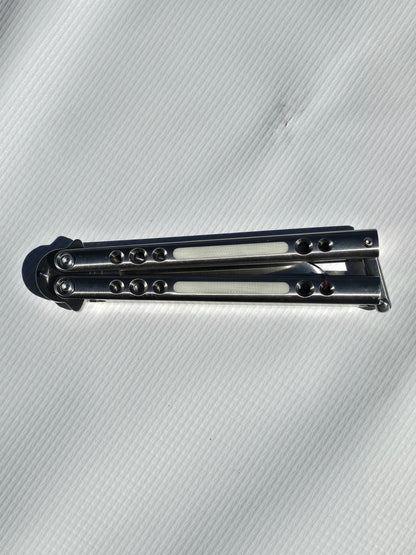 BaliBalistic ported and white G10 inlaid 1/2 inch thick titanium channel cut handles with a latch that are paired up to a Bowie clip point blade