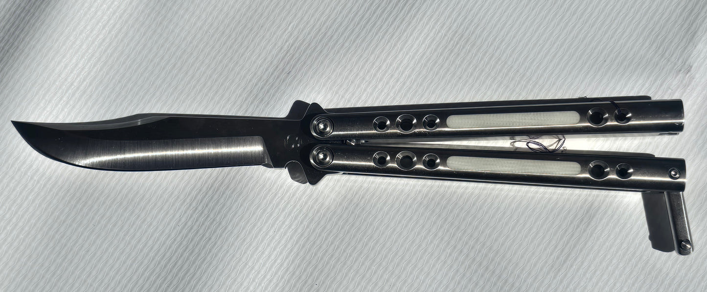 BaliBalistic ported and white G10 inlaid 1/2 inch thick titanium channel cut handles with a latch that are paired up to a Bowie clip point blade